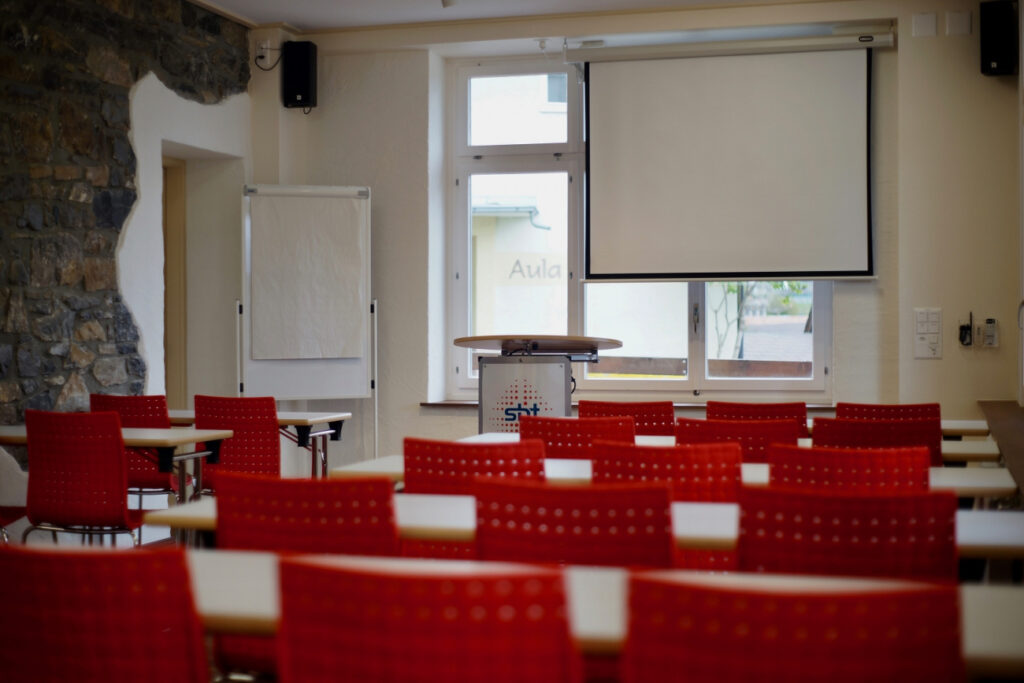 Flipchart und Leinwand mit Seminarbestuhlung